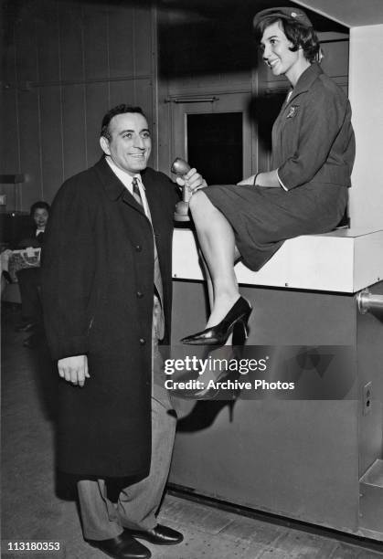 American singer Tony Bennett serenades TWA air hostess Gabriele Lehman prior to flying from New York to London on April 14, 1961.