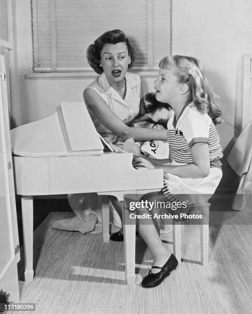 Model Frances Bergen singing with her young daughter Candice Bergen circa 1952.