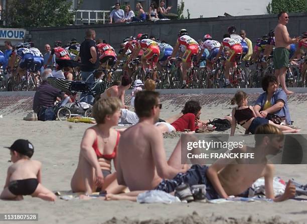 Des personnes regardent le peloton qui roule en bord de mer, le 13 mai 2001 à Dunkerque, lors de la 7e et dernière étape des Quatre Jours de...