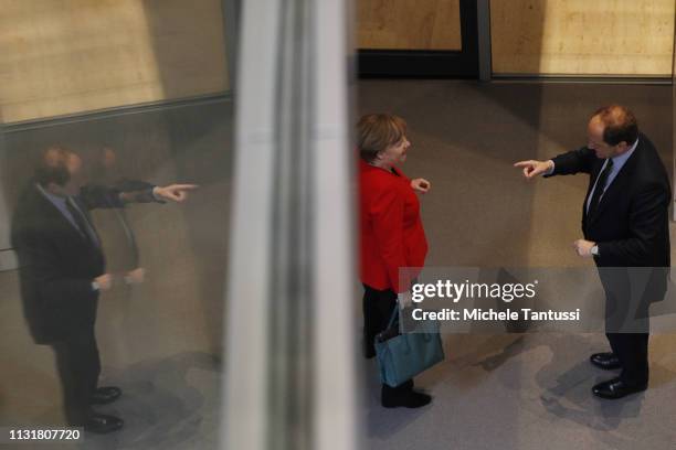 German Chancellor Angela Merkel chats with a member of the parliament as she leaves after a government declaration at the Bundestag before traveling...