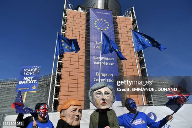 Protesters wearing costumes of Germany's Chancellor Angela Merkel and Britain's Prime Minister Theresa May and waving United Kingdom and European...