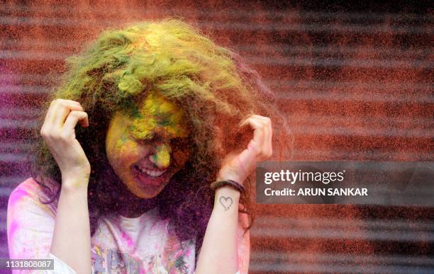 An Indian girl gets reacts as she thrown coloured powder during Holi festival celebrations in Chennai on March 21, 2019. - Holi, the popular Hindu...