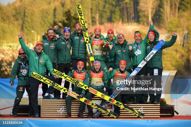 Gold medalists Markus Eisenbichler, Karl Geiger, Richard Freitag and Stephan Leyhe of Germany pose for a photo with their team following their...
