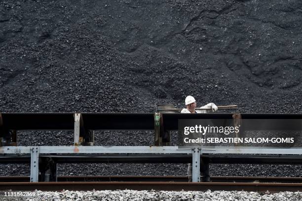 Worker carries tools on his shoulder at the French energy giant EDF coal-fired powerplant of Cordemais, western France, on March 21, 2019.