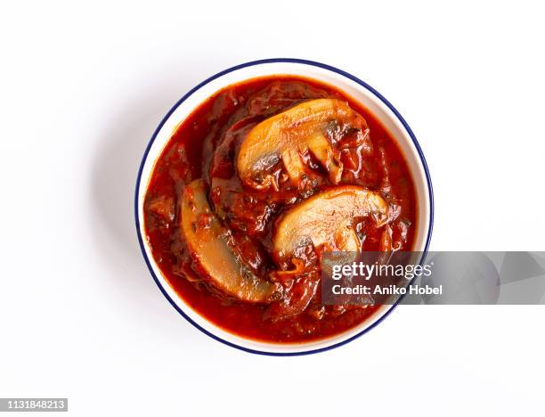 mushrooms in tomato sauce on white background - white mushroom ストックフォトと画像