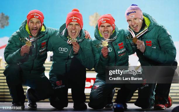 Gold medalists Markus Eisenbichler, Karl Geiger, Richard Freitag and Stephan Leyhe of Germany pose with the medals during the medal ceremony for the...