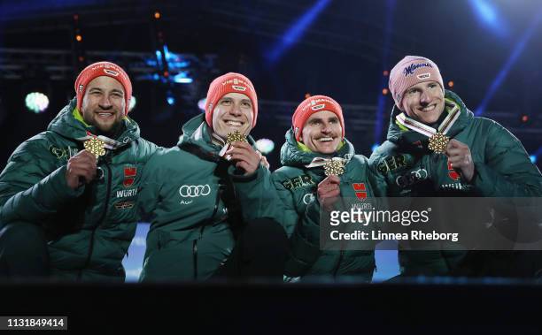 Gold medalists Markus Eisenbichler, Karl Geiger, Richard Freitag and Stephan Leyhe of Germany pose with the medals during the medal ceremony for the...
