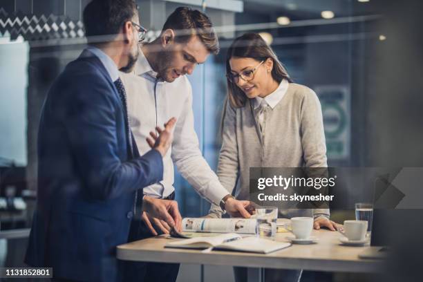 team of entrepreneurs reading a magazine in the office. - glass magazine stock pictures, royalty-free photos & images