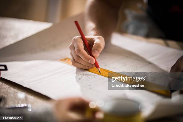 close up of unrecognizable male architect making measurements on housing project. - architect stock pictures, royalty-free photos & images