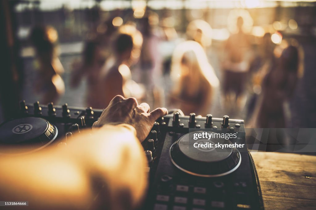 Nahaufnahme eines DJ, der auf der Strandparty Musik spielt.