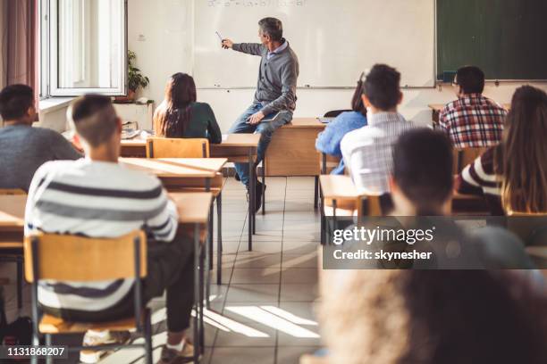 profesor de sexo masculino de mediana edad dando una conferencia a sus estudiantes en el aula. - male professor with students fotografías e imágenes de stock