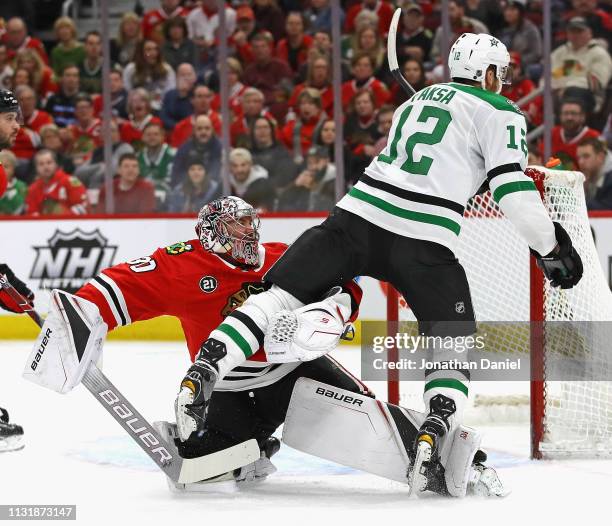 Radek Faksa of the Dallas Stars trips over Cam Ward of the Chicago Blackhawks at the United Center on February 24, 2019 in Chicago, Illinois.