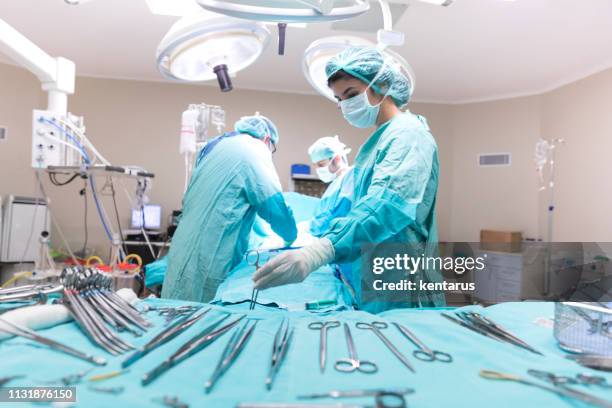 medical team performing surgical opertion - obstetric forceps stock pictures, royalty-free photos & images