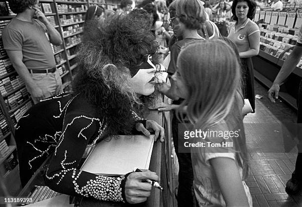 Kiss singer-guitarist Paul Stanley signs autographs for fans during an in-store appearance at Peaches Records in Atlanta, Georgia on August 14, 1976.