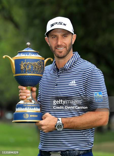 Dustin Johnson of the United States holds the Gene Sarazen Trophy after his five shot victory during the final round of the World Golf...