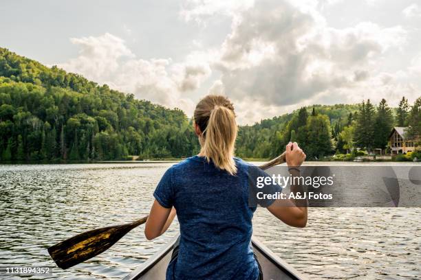 portuguese woman canoeing on a lake at sunset. - quebec landscape stock pictures, royalty-free photos & images
