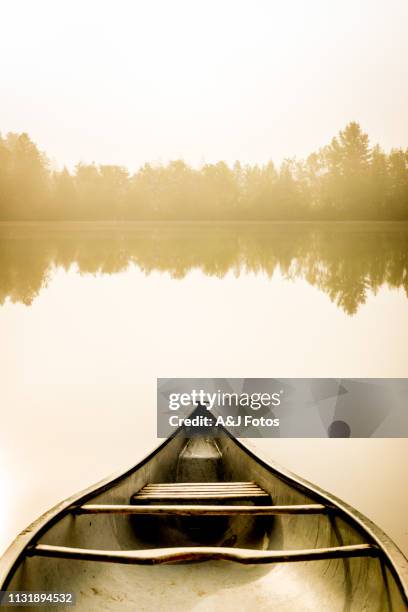 peaceful fishing lake and canoe at sunrise. - canoe stock pictures, royalty-free photos & images