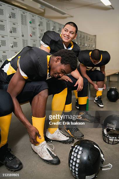 football players dressing in locker room - young boys changing in locker room imagens e fotografias de stock