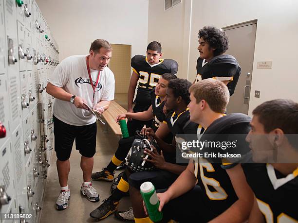 coach talking to football players in locker room - high school sports team stock pictures, royalty-free photos & images