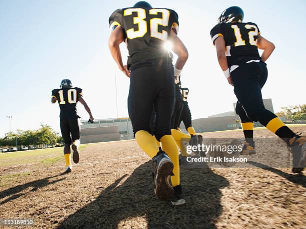 football players running on football field - profundo jugador de fútbol americano fotografías e imágenes de stock