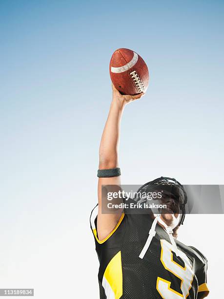 hispanic football player lifting football - touch down foto e immagini stock