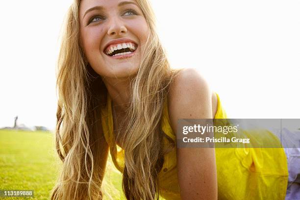 smiling caucasian woman laying in grass - woman looking up sideview stock-fotos und bilder