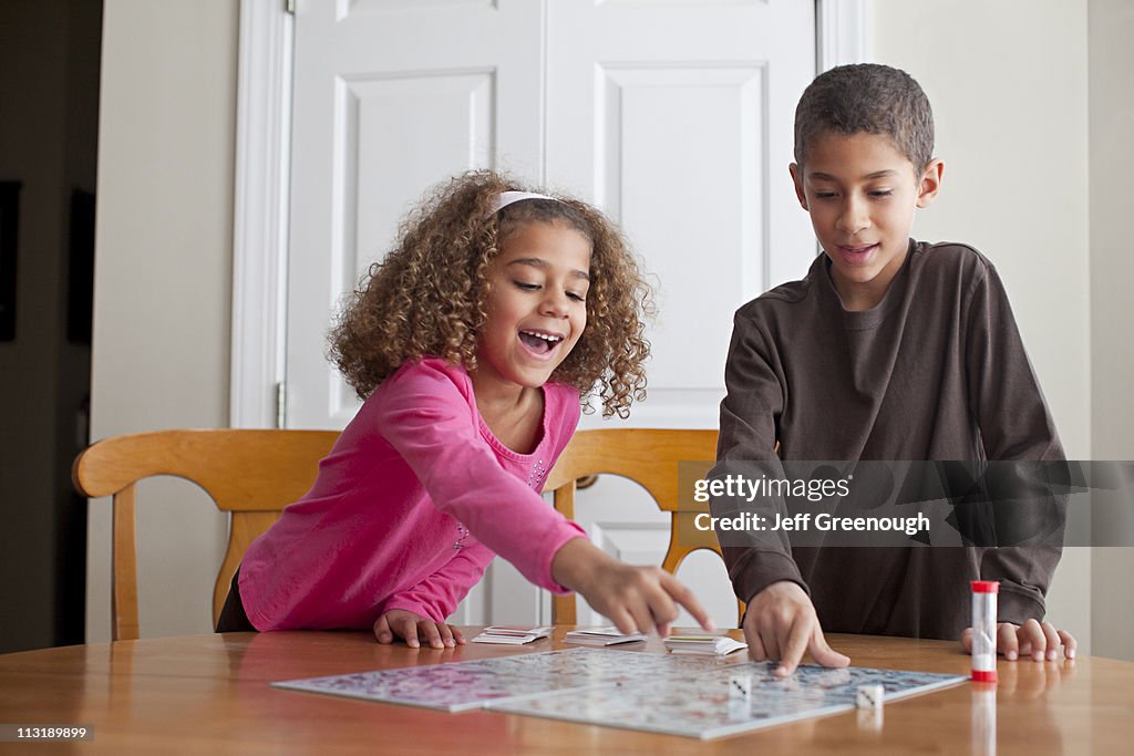 Mixed race children playing board game together