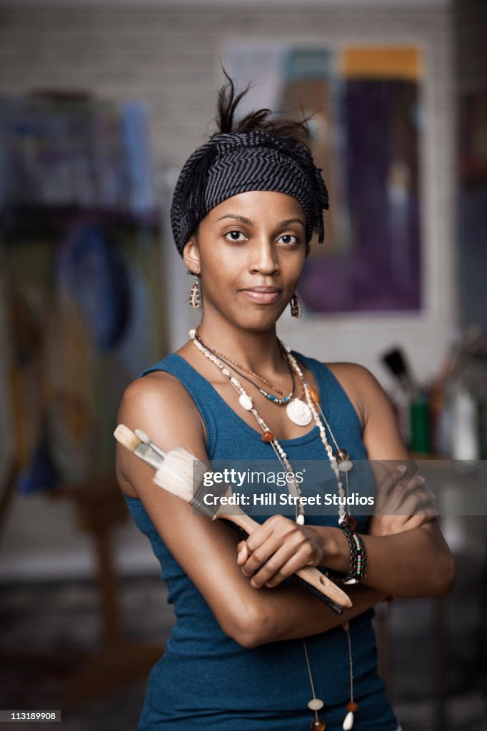 Mixed race woman standing in artist's studio
