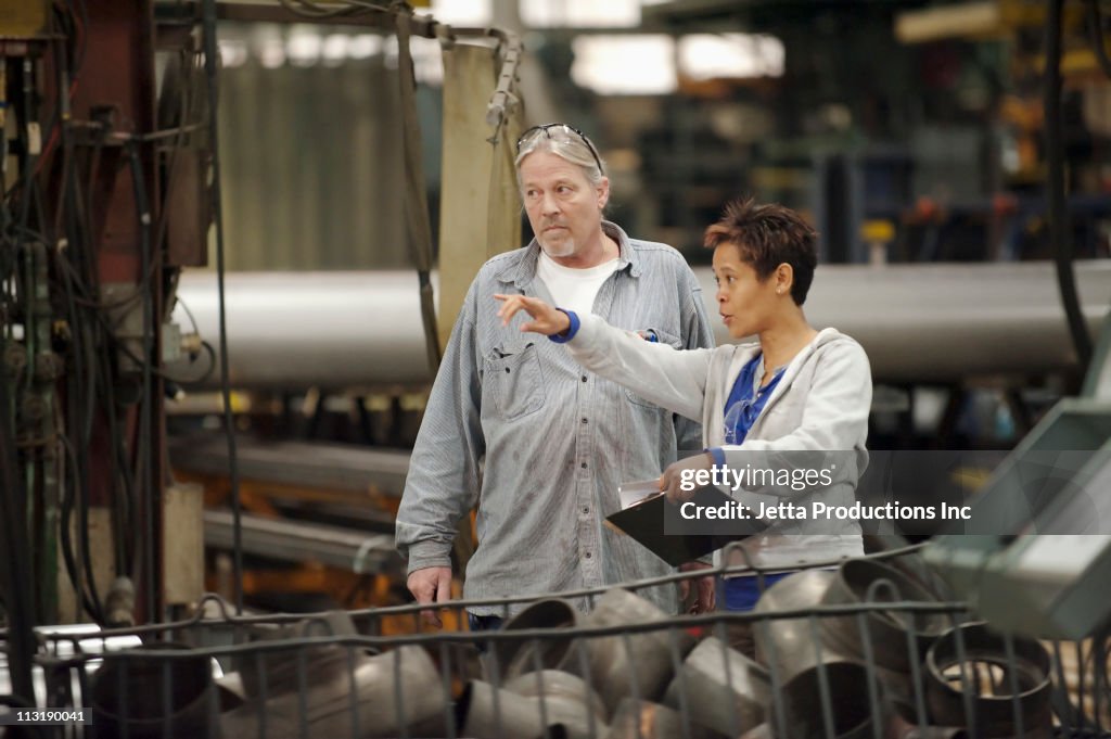 Manager and worker talking in factory