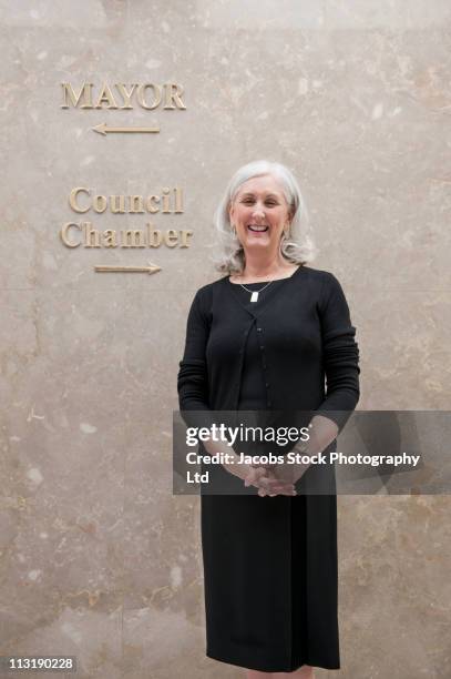 caucasian businesswoman standing in office corridor - mayor office stock pictures, royalty-free photos & images