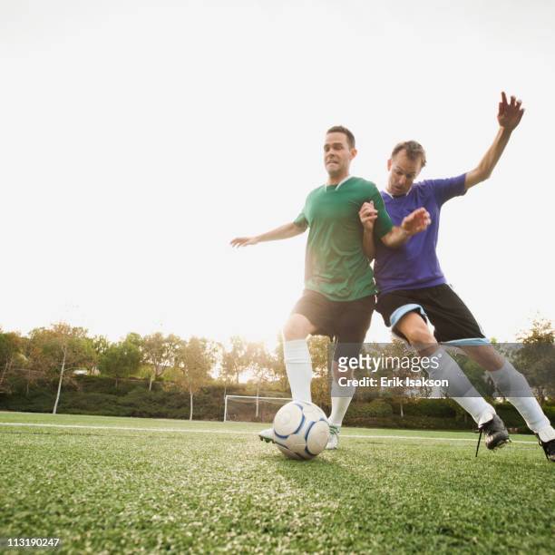 men playing soccer on soccer field - verteidigen stock-fotos und bilder