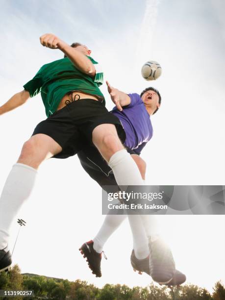 soccer players heading soccer ball - verteidiger fußball stock-fotos und bilder