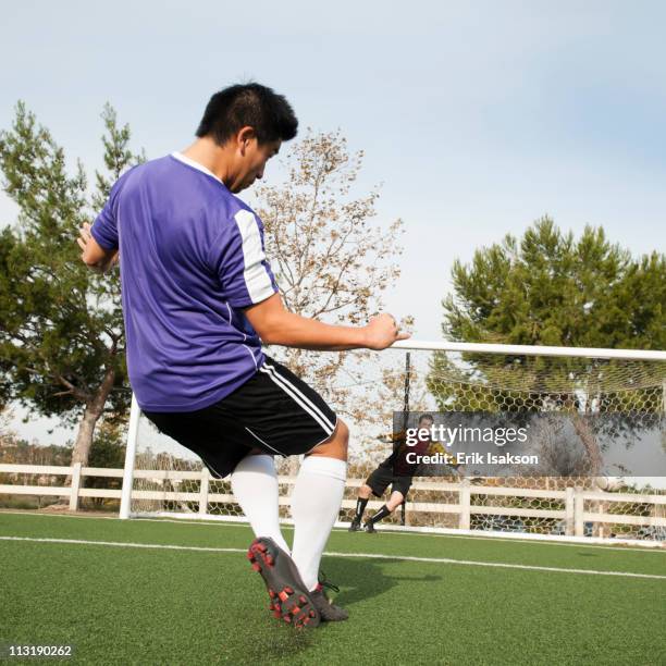 soccer player kicking ball into goal on soccer field - guard american football player 個照片及圖片檔