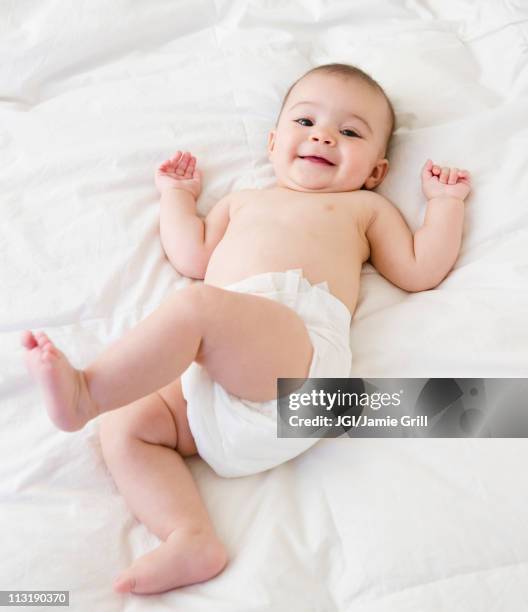 mixed race baby laying on bed - baby diaper laying down stock pictures, royalty-free photos & images