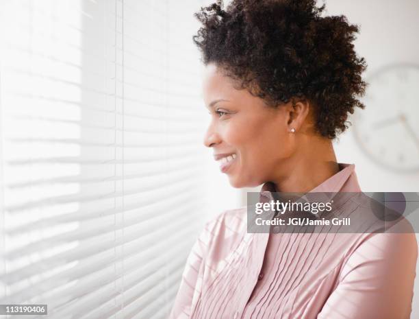 black businesswoman looking out window - business frau profil kurze haare stock-fotos und bilder