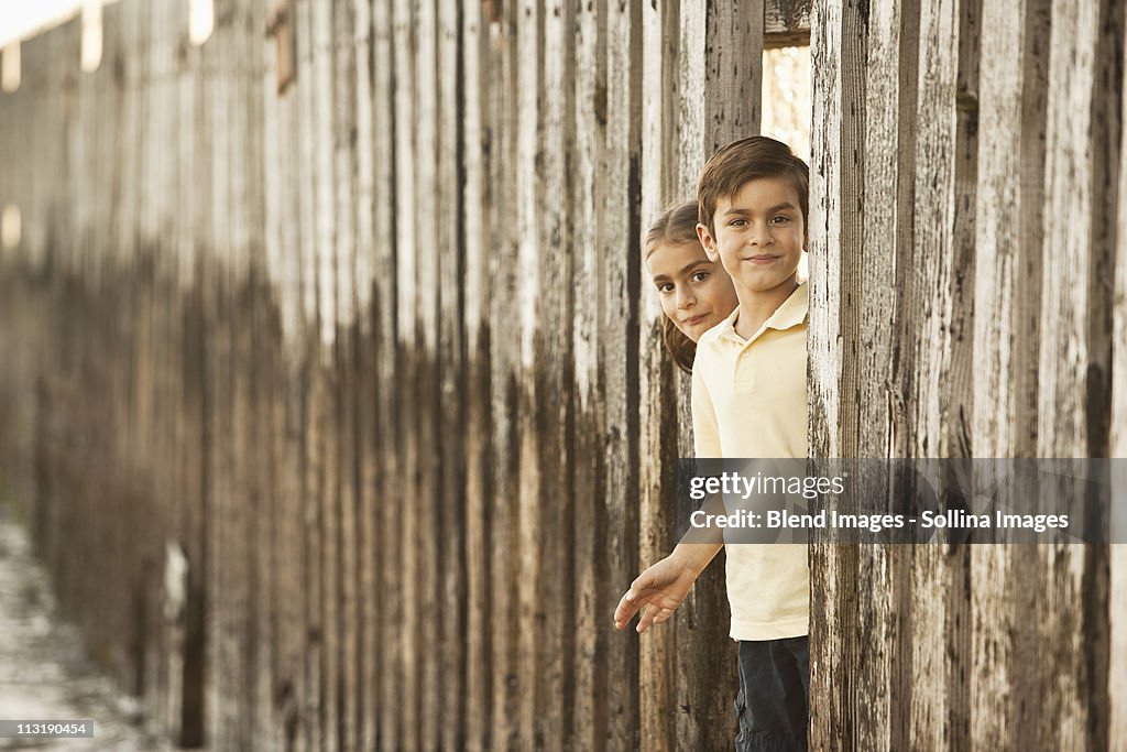 Mixed race brother and sister playing near wall