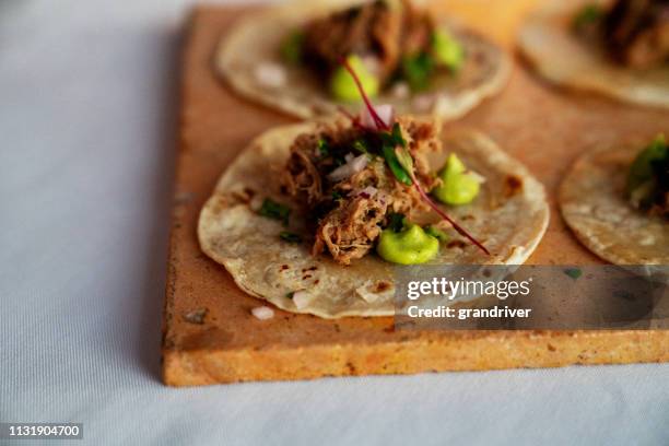tacos de ternera rallado bellamente estilo en tortillas de maíz con puntos de guacamole - taco fotografías e imágenes de stock
