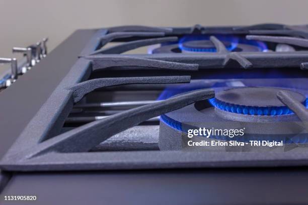 restaurant stove top view with burner lit with natural blue flame gas. - equipamento stock-fotos und bilder