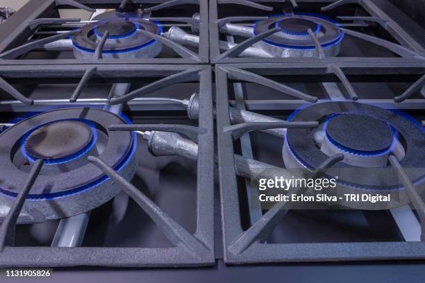 professional stove burners ignited with natural blue flame gas. - equipamento stock-fotos und bilder