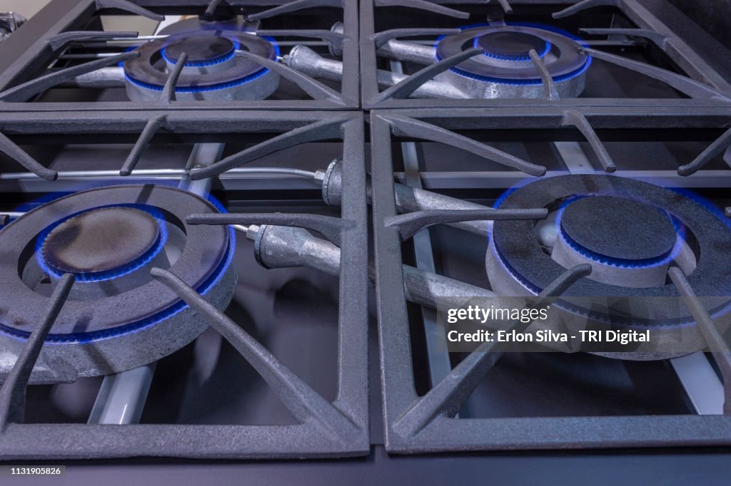 Professional stove burners ignited with natural blue flame gas.