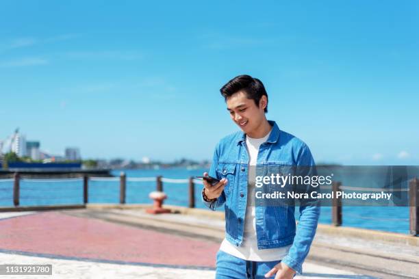 man holding smartphone - digital nomad - sabah state stock pictures, royalty-free photos & images