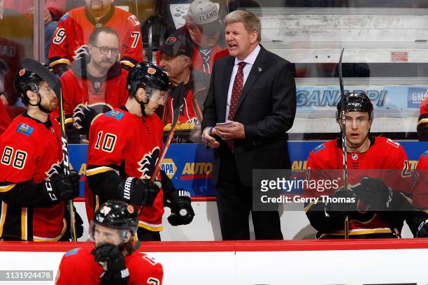 Head coach Bill Peters of the Calgary Flames stands on the bench during an NHL game against the Ottawa Senators on March 21, 2019 at the Scotiabank...