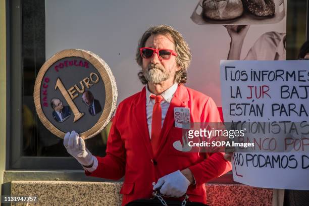 Man dressed as santander bank worker seen holding an Euro coin during the protest. Demonstration against the popular bank, a group of the Santander...