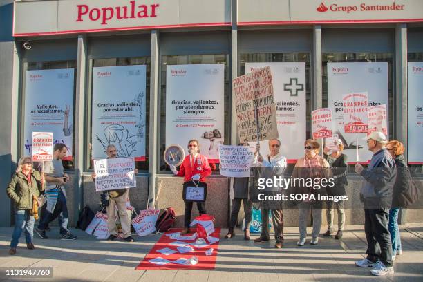 Protesters are seen holding placards in front of the popular bank during the demonstration. Demonstration against the popular bank, a group of the...