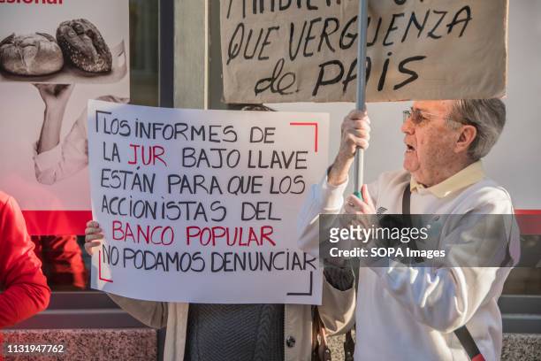 An elderly man seen holding a placard that says what a shame of country during the protest. Demonstration against the popular bank, a group of the...