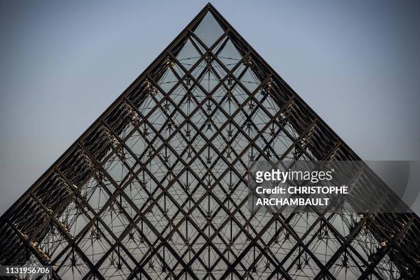The Louvre museum pyramid is pictured at dawn in Paris on March 22, 2019. - Chinese born US architect Ieoh Ming Pei's pyramid celebrates its 30th...