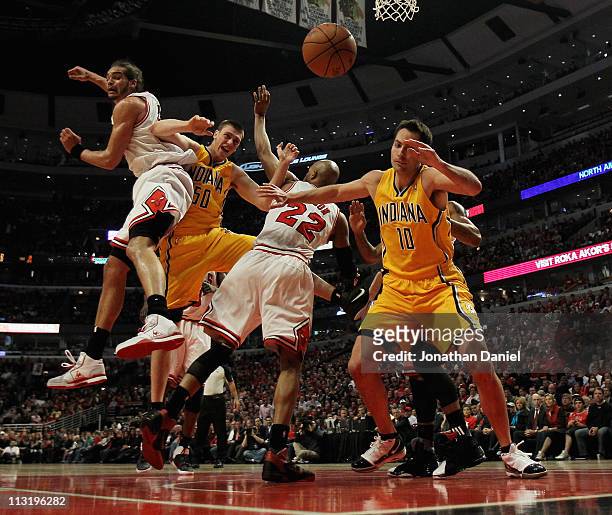 Tyler Hansbrough of the Indiana Pacers looses control of the ball under pressure from Joakim Noah and Taj Gibson of the Chicago Bulls as Jeff Foster...