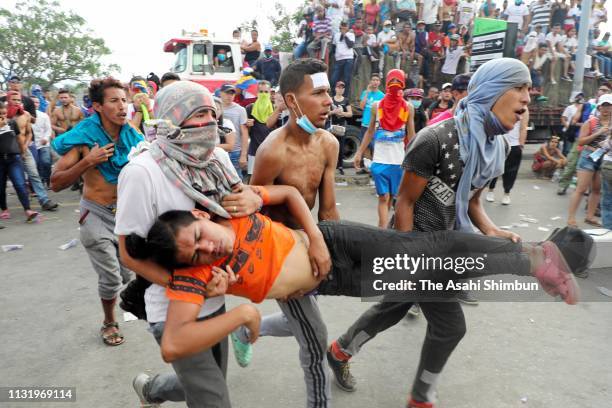 An injured Venezuelan man is carried after clash with Venezuelan National Guard soldiers who close at the Simon Bolivar international bridge on...