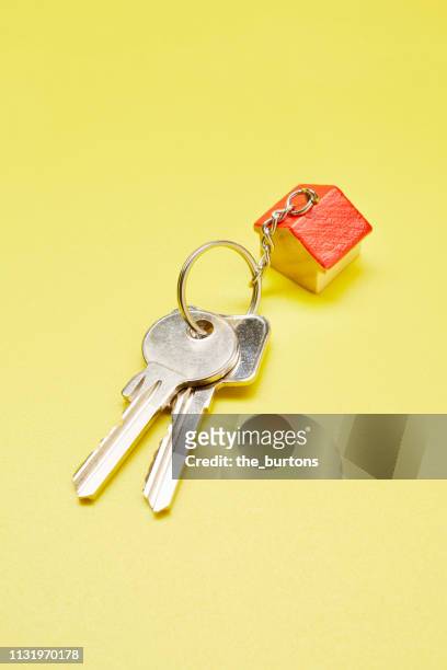 High angle view of keyring with a small house on colored background