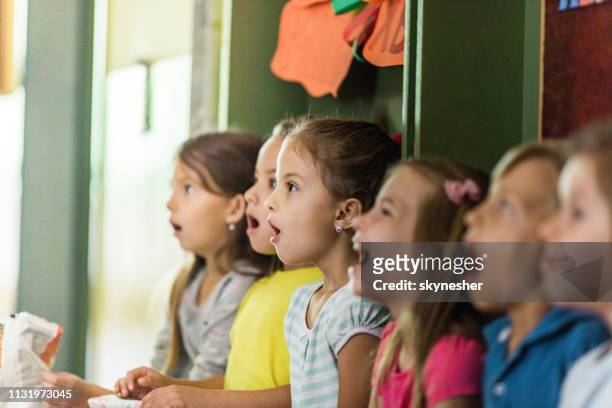grupo de estudiantes de primaria cantando en coro en la escuela. - coro fotografías e imágenes de stock